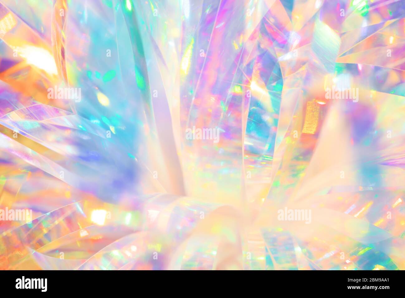 Texture abstraite festive et gaie du ruban en papier d'aluminium holographique aux couleurs de bonbons avec reflets de lumière étincelants Banque D'Images