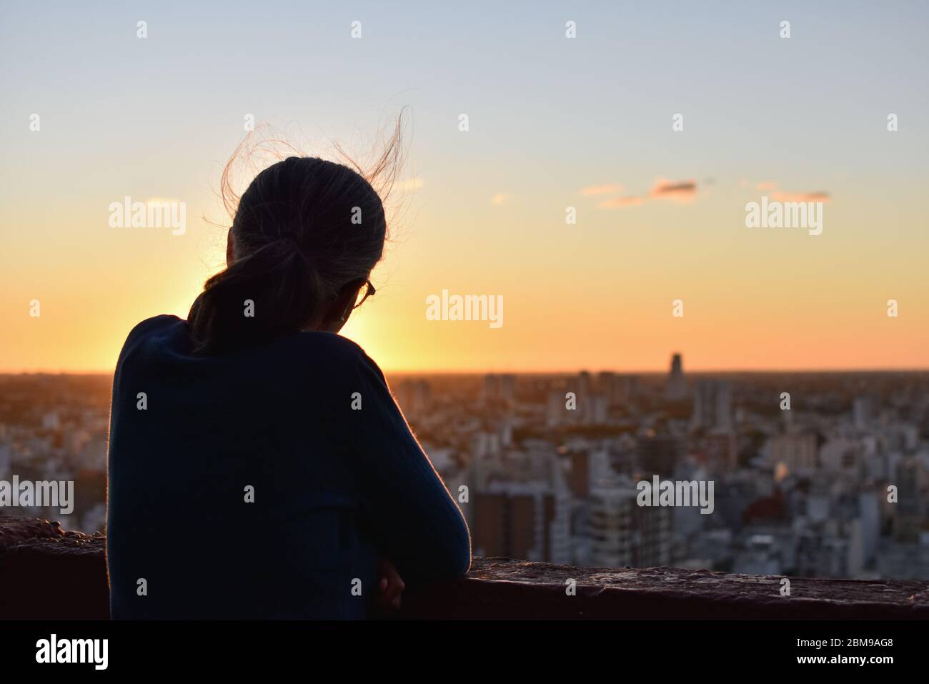 Une femme qui regarde la ville de Buenos Aires en profitant du coucher de soleil Banque D'Images