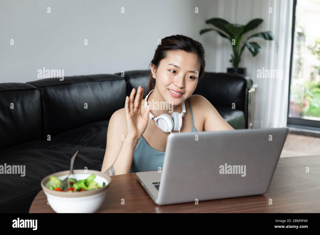 Une jeune femme asiatique utilisant un ordinateur dans le salon Banque D'Images