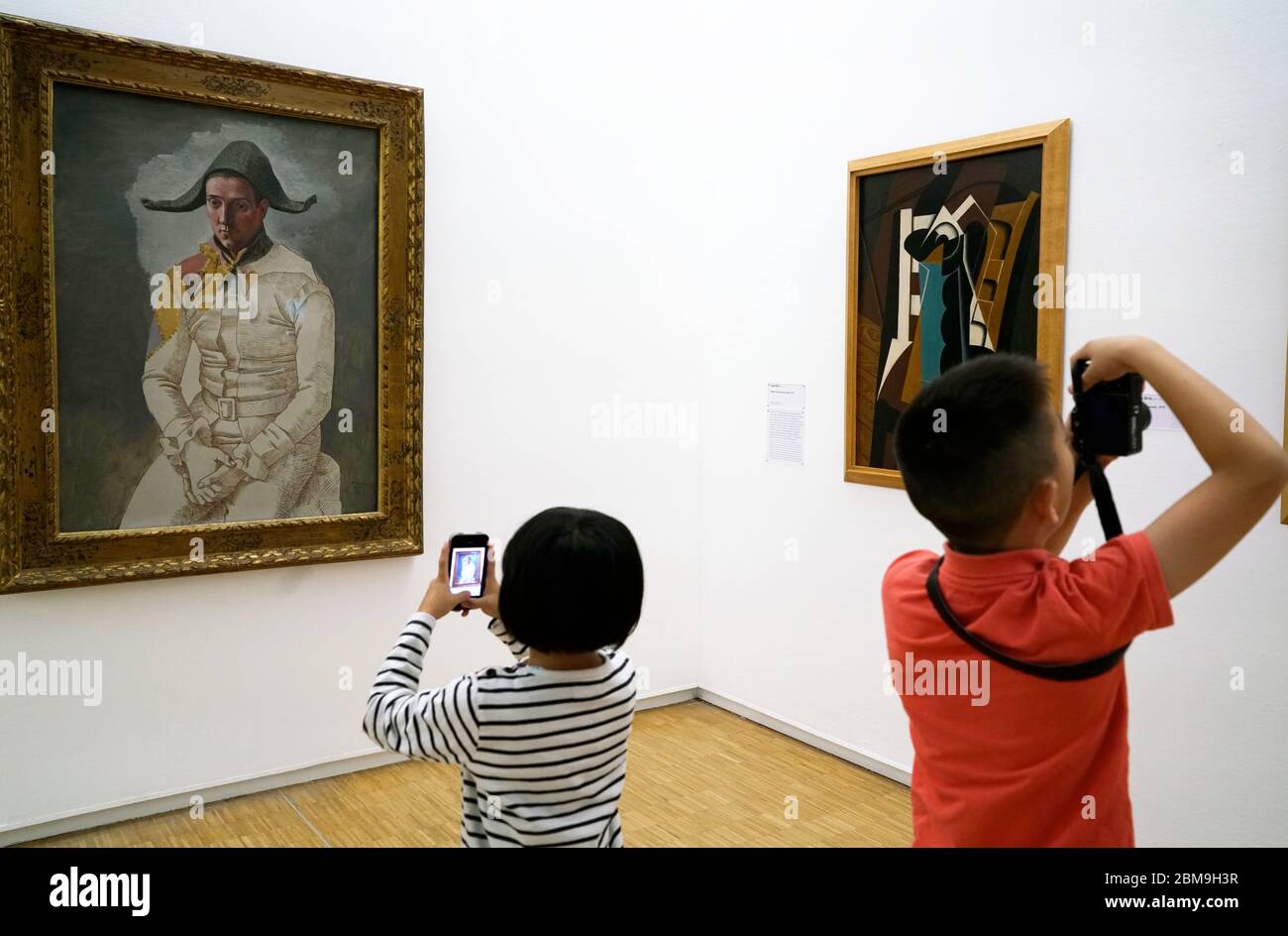 Les enfants qui prennent des photos devant l'exposition d'Arlequin assis de Pablo Picasso au Centre Pompidou.Paris.France Banque D'Images