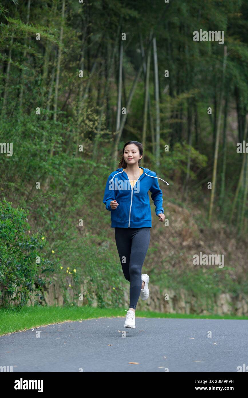 Une jeune femme asiatique court Banque D'Images