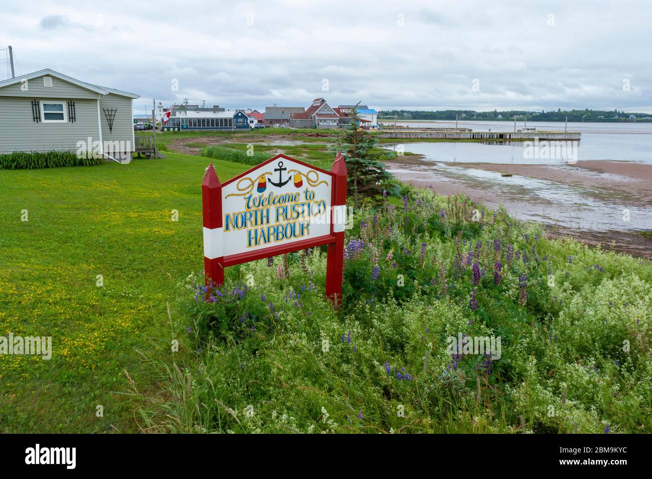 Bienvenue au port de North Rustico. Panneau de ville peint accueillant les visiteurs. Vue sur le port et les bâtiments du restaurant près d'un quai. I.-P.-É., Canada Banque D'Images