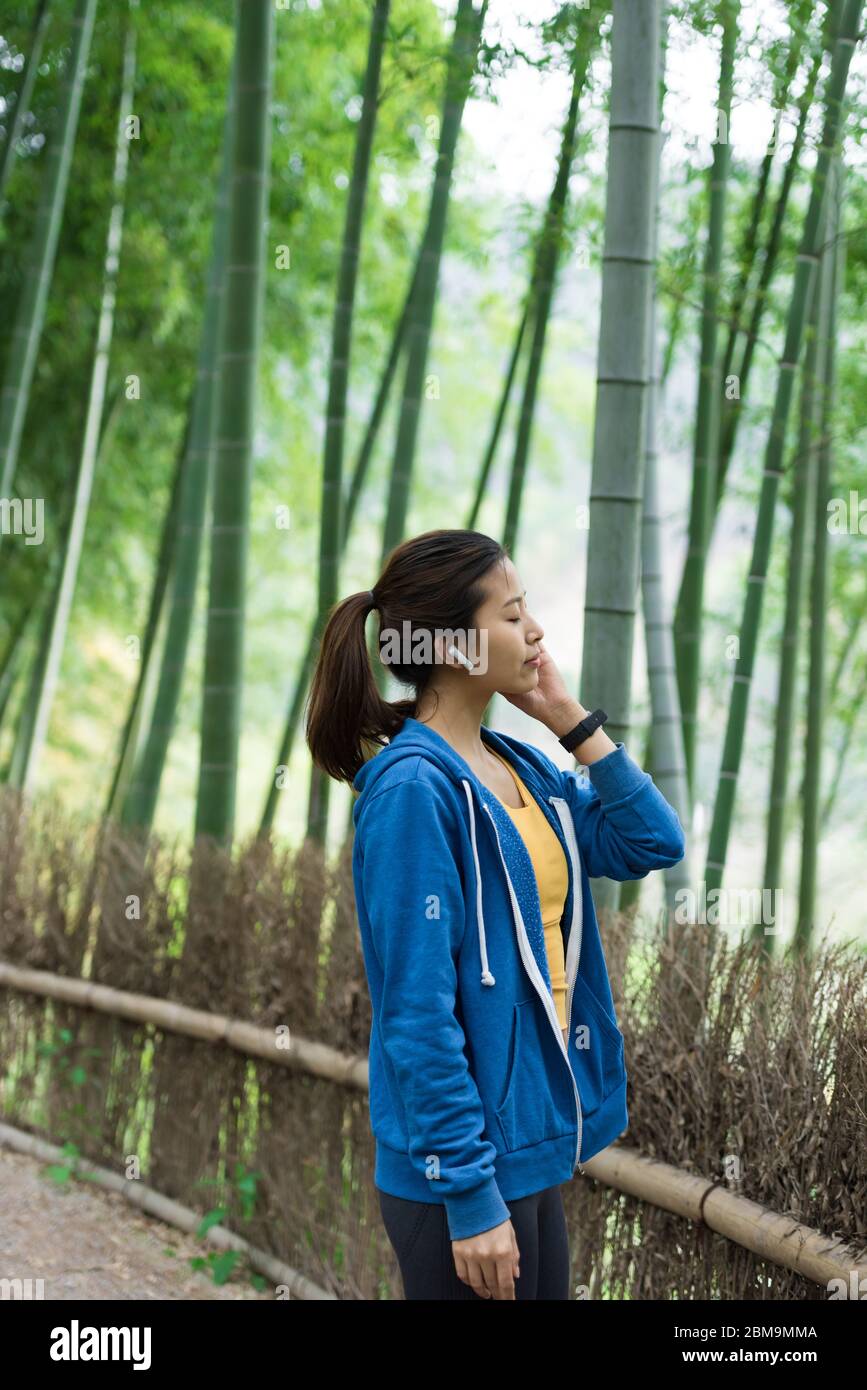 Une jeune femme asiatique marche et s'y repose dans une forêt de bambou Banque D'Images