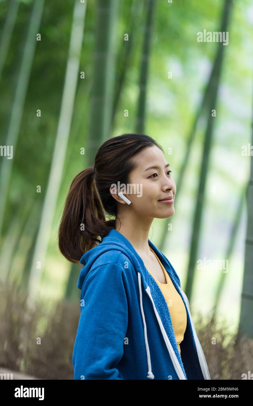 Une jeune femme asiatique marche et s'y repose dans une forêt de bambou Banque D'Images