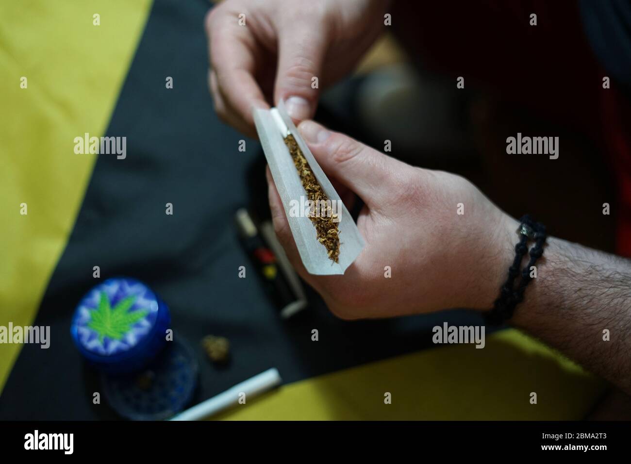 L'homme prépare un joint pour fumer de la marijuana Banque D'Images