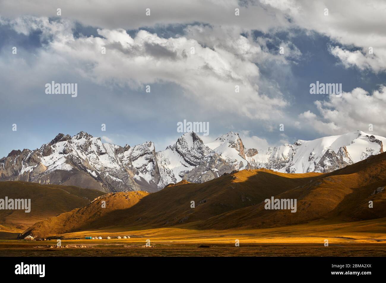 De beaux paysages de montagnes aux sommets enneigés et camp de yourte dans la vallée près de Kel Suu Lake dans la région de Naryn, Kirghizistan Banque D'Images