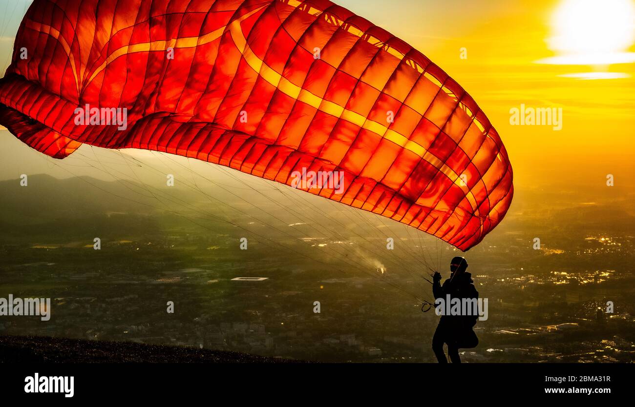 Silhouette d'un homme le parapente au coucher du soleil, Salzbourg, Autriche Banque D'Images