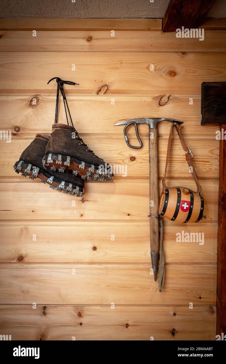 Des bottes en cuir d'escalade vintage et une hache à glace sont accrochées  à un mur en bois. Matériel d'escalade antique Photo Stock - Alamy