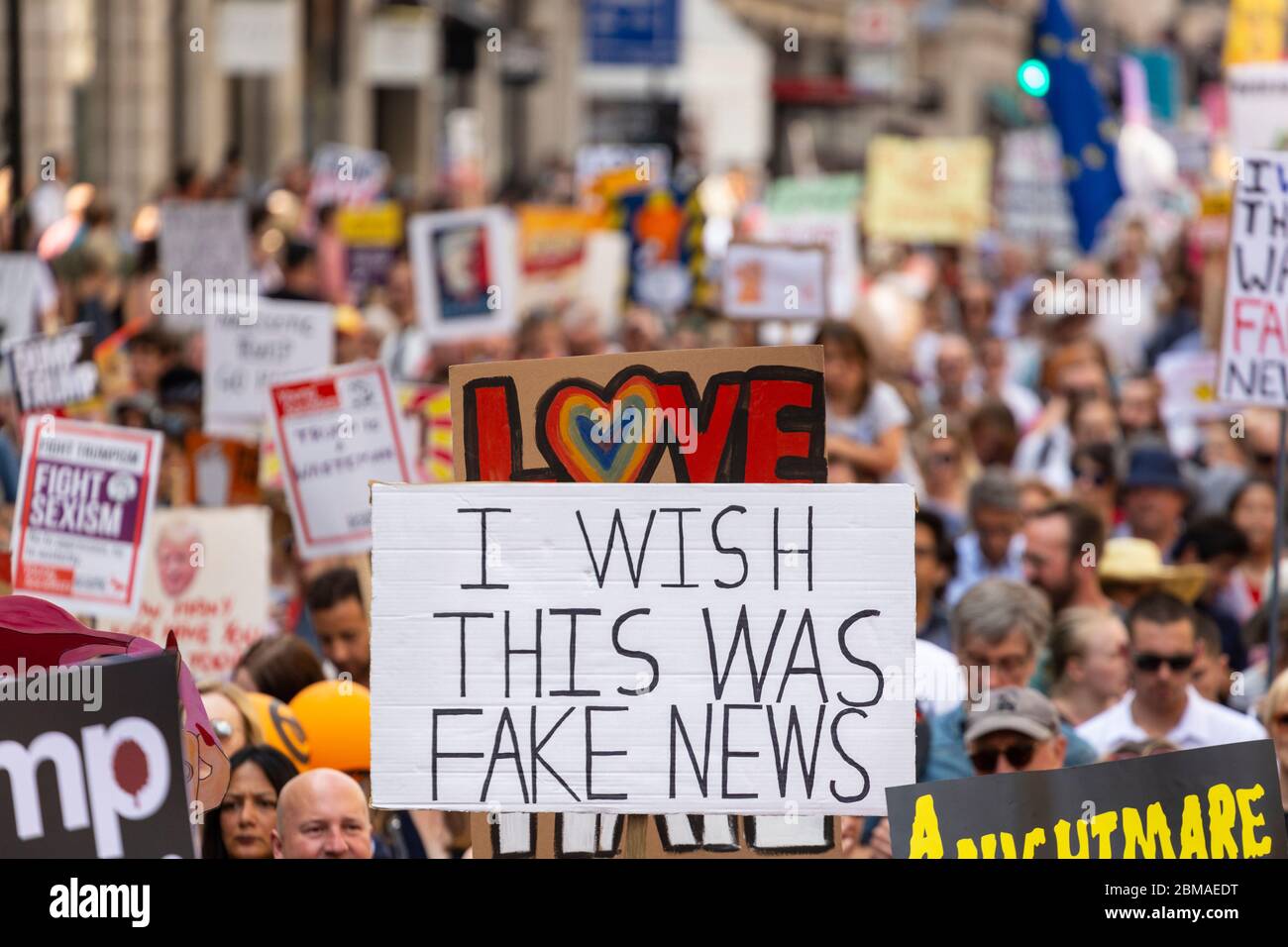 Un panneau se tient au-dessus d'une foule qui lisait « Je souhaite que ce soit une fake news », lors de la manifestation contre la visite de Donald Trump à Londres, le 13 juillet 2018 Banque D'Images