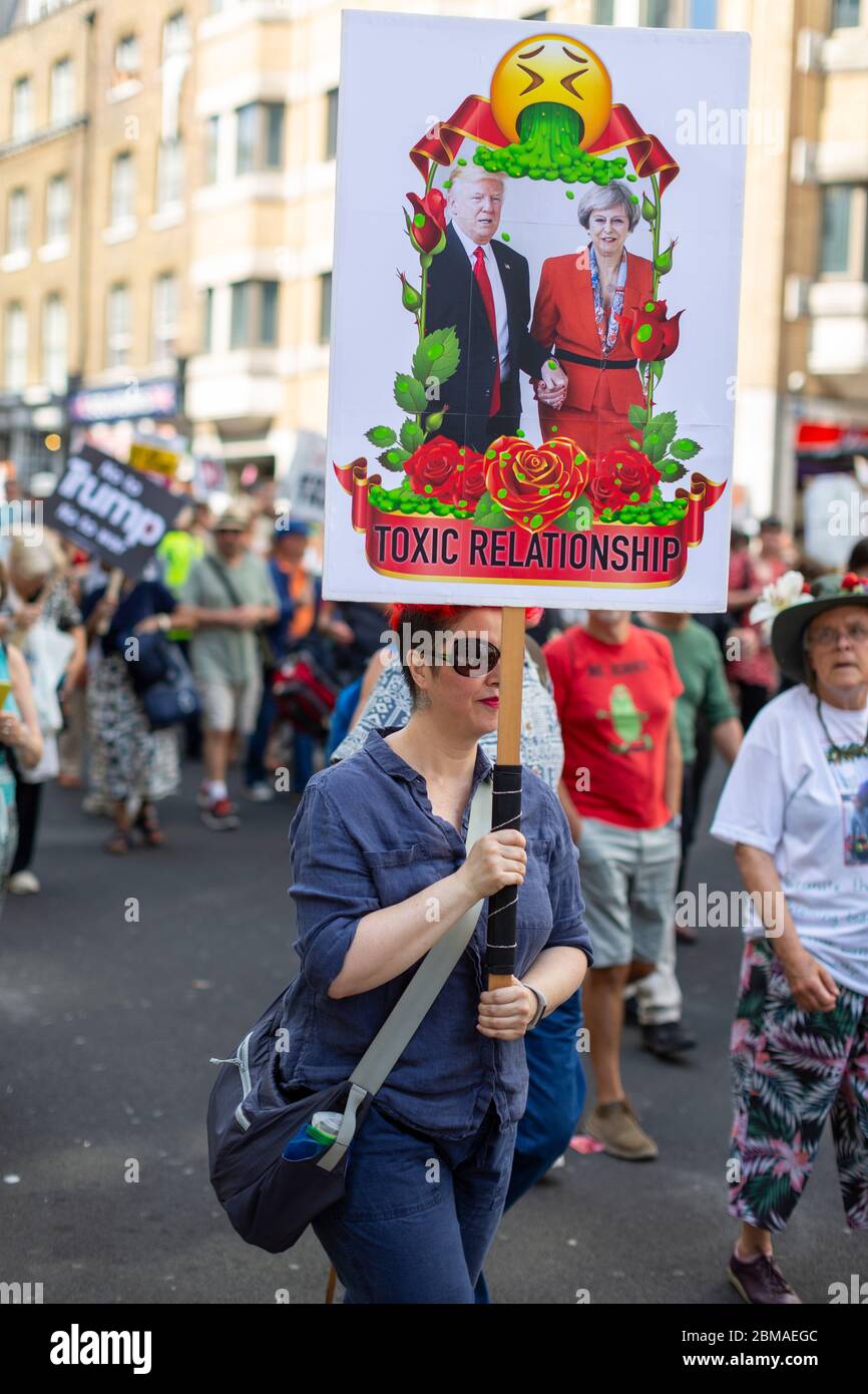 Une femme tenant un panneau avec une image de Donald Trump et Theresa May et un texte lisant "Toxic Relationship" lors d'une manifestation à Londres, le 13 juillet 2018 Banque D'Images