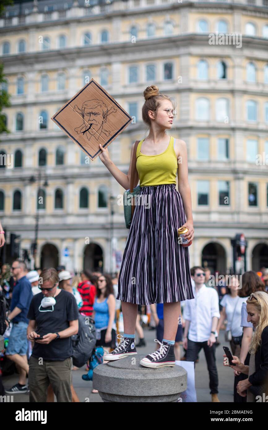 Une jeune femme debout et tenant un panneau à la manifestation contre la visite de Donald Trump à Londres, le 13 juillet 2018 Banque D'Images