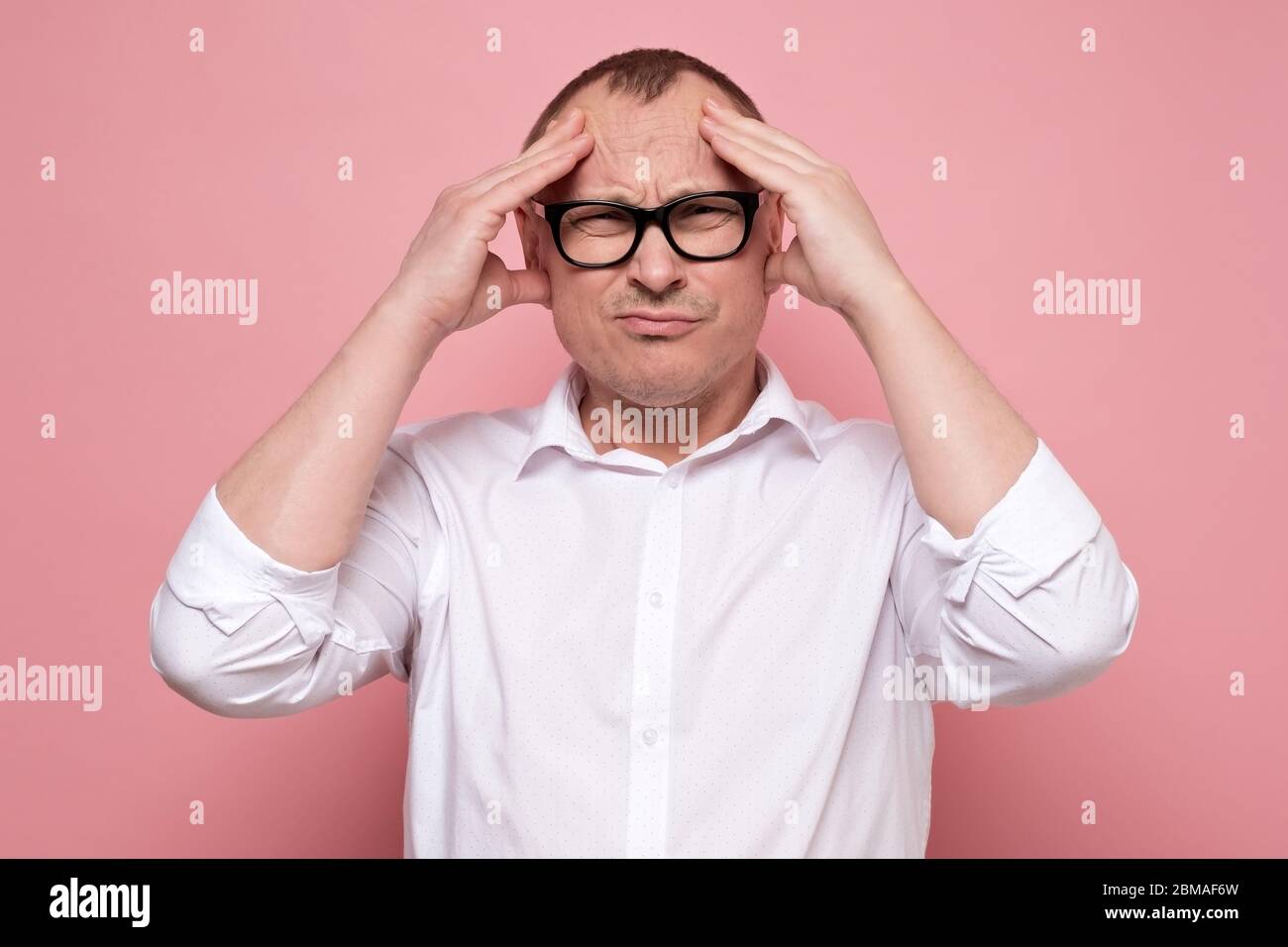 Un jeune homme stressé dans des lunettes regrettant quelque chose, regardant l'appareil photo. Banque D'Images