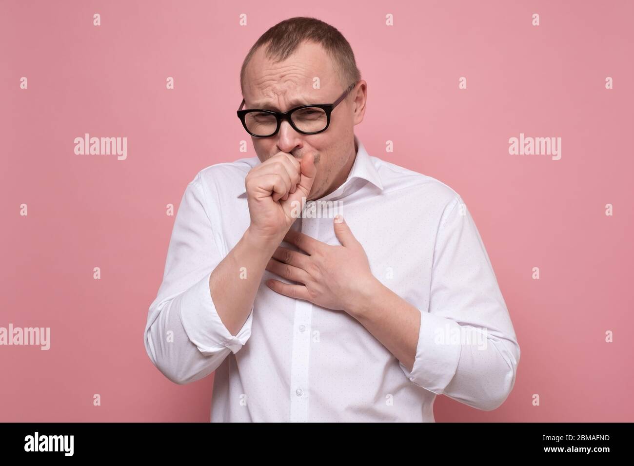 Homme caucasien mature toussant à cause de la grippe ou de la grippe Banque D'Images