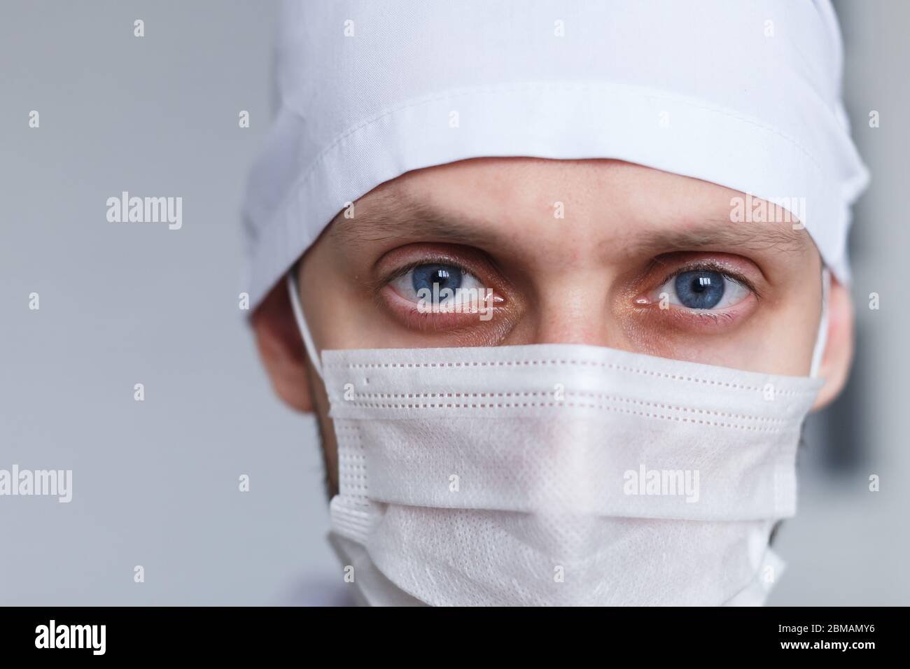 Jeune homme fatigué médecin dans le masque pendant le coronavirus. Portrait dramatique de medic, gros plan Banque D'Images