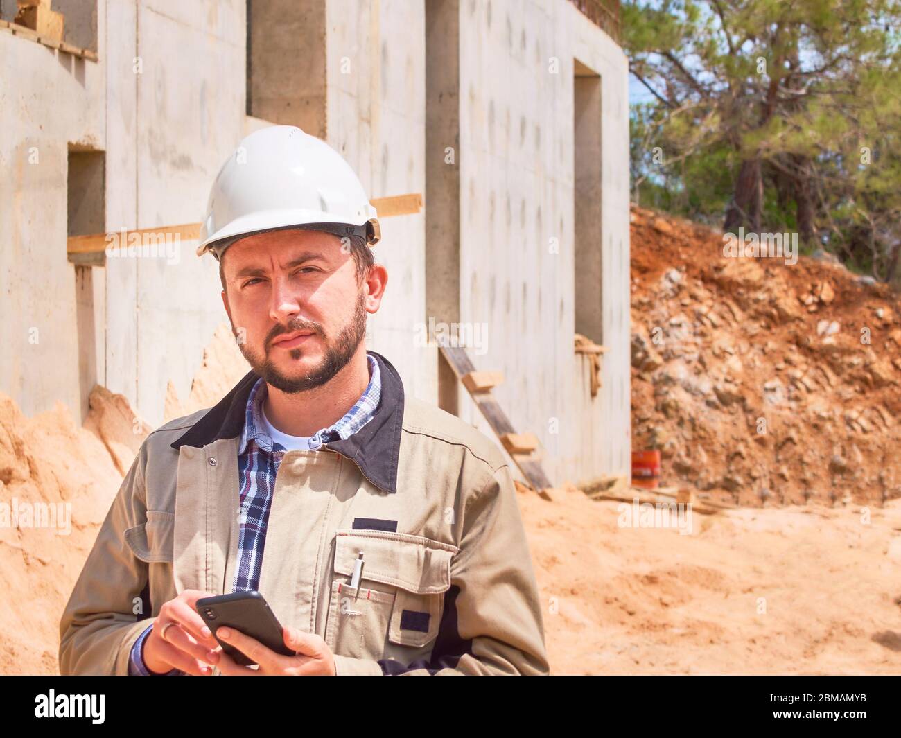 Un ingénieur civil caucasien ou un ouvrier de construction en casque blanc utilise son site de construction opposé Banque D'Images