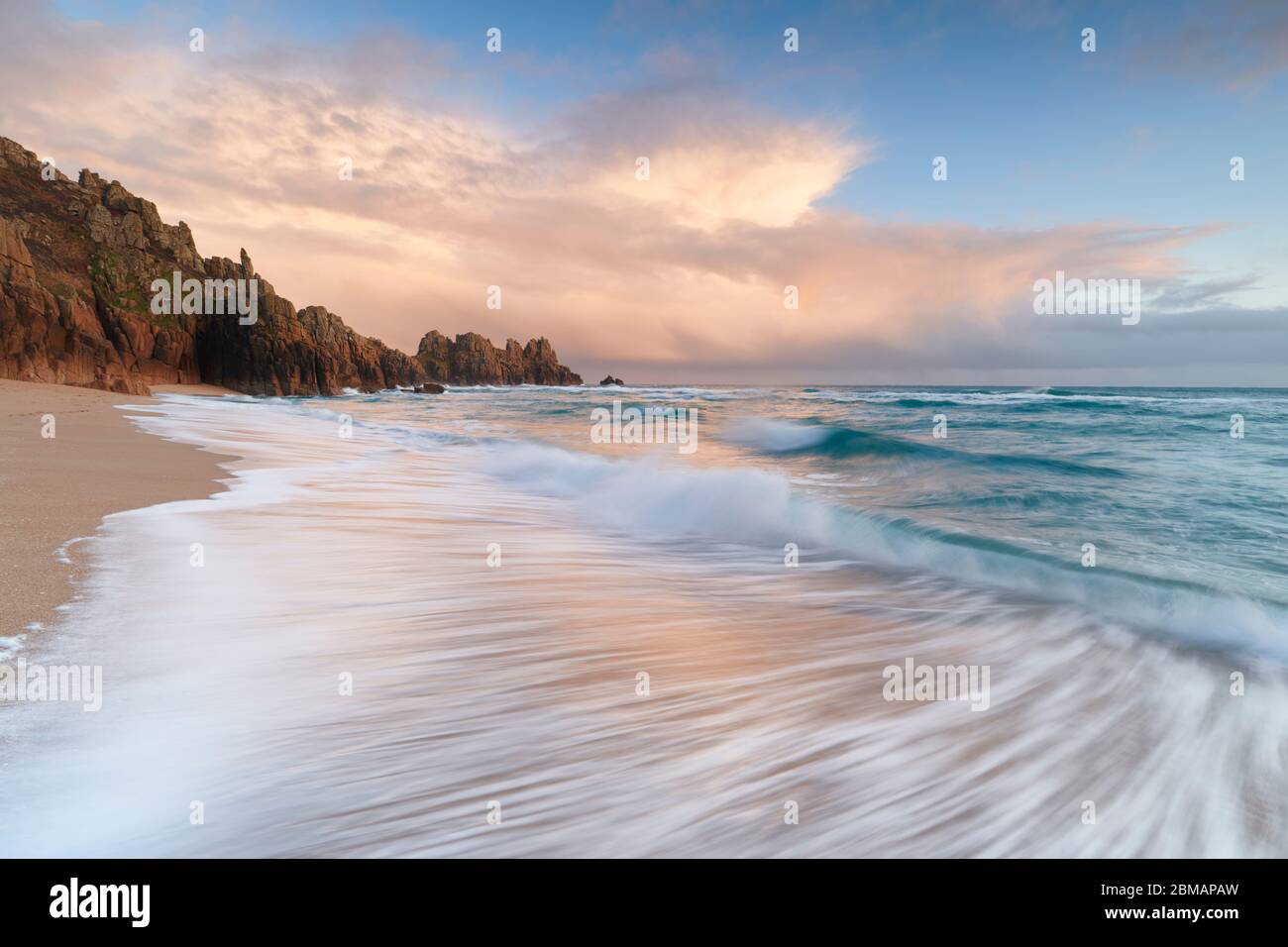 Le soleil du soir éclaire les nuages à la plage de Porthcurno Banque D'Images