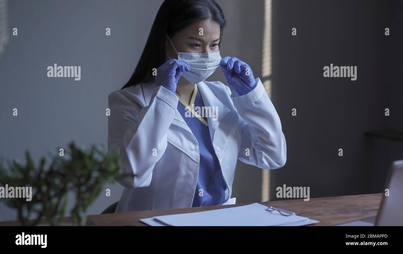 Médecin travaillant sur l'ordinateur. Joli travailleur médical corracts masque médique lors de la conduite de recherches informatiques dans le domaine de la médecine. Recherche médicale Banque D'Images