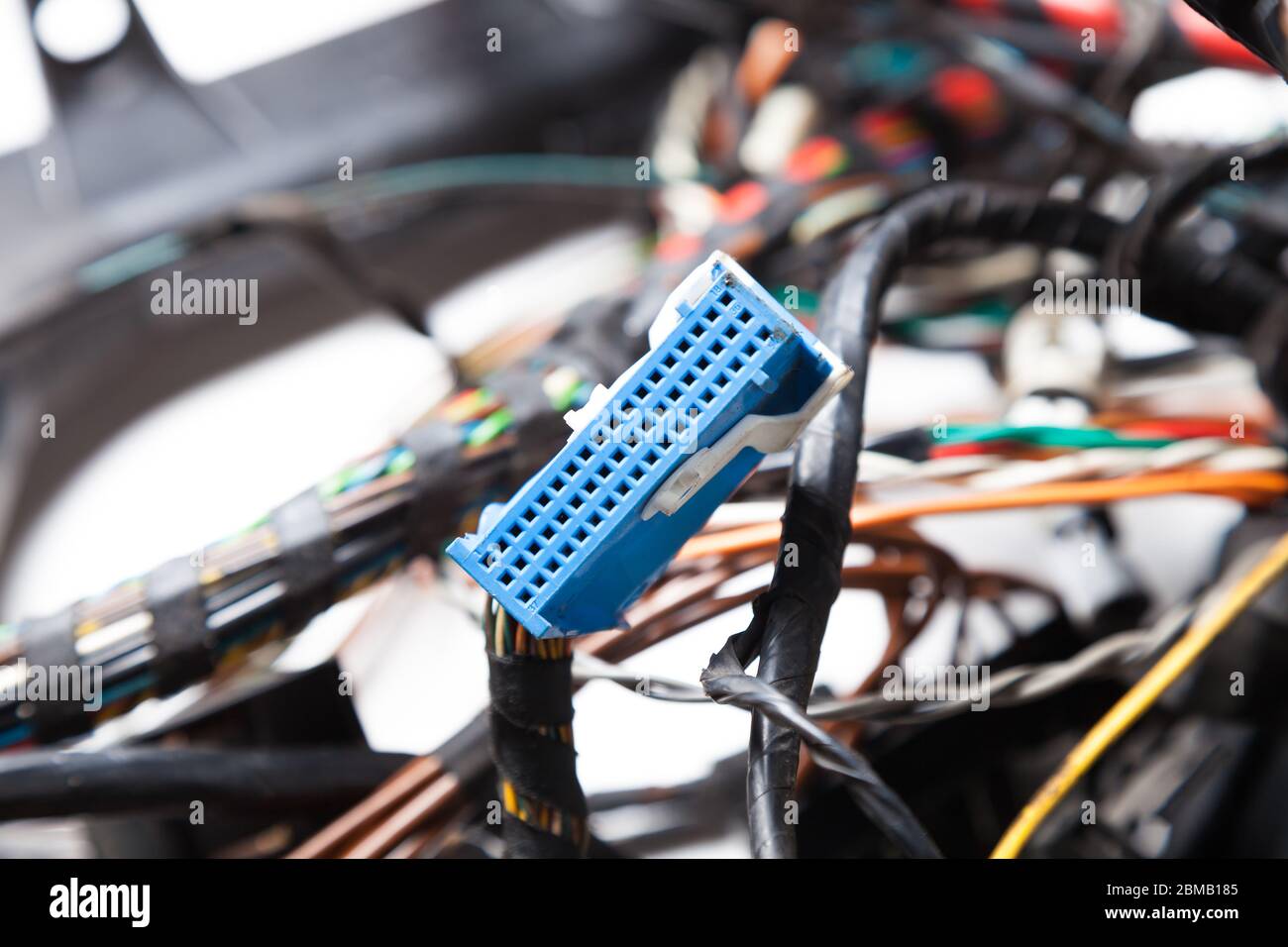 Gros plan sur le connecteur bleu sur l'arrière-plan des fils et des chaînes numériques enchevêtrés. Réseau Internet de connexion d'un développeur INFORMATIQUE sur un site distant. Banque D'Images