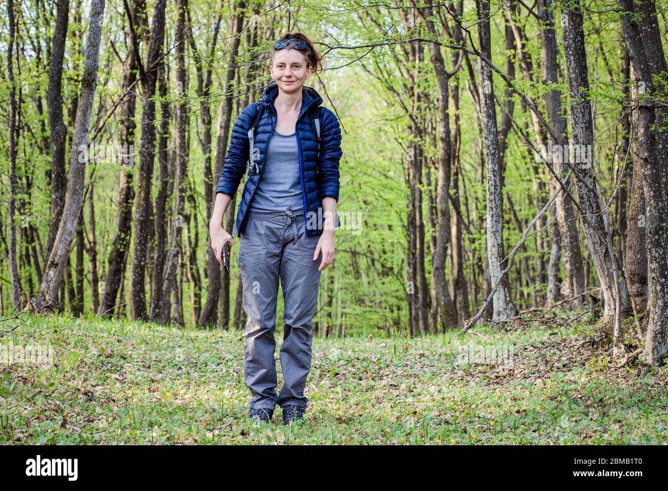 femme trekking seule dans la forêt verte Banque D'Images