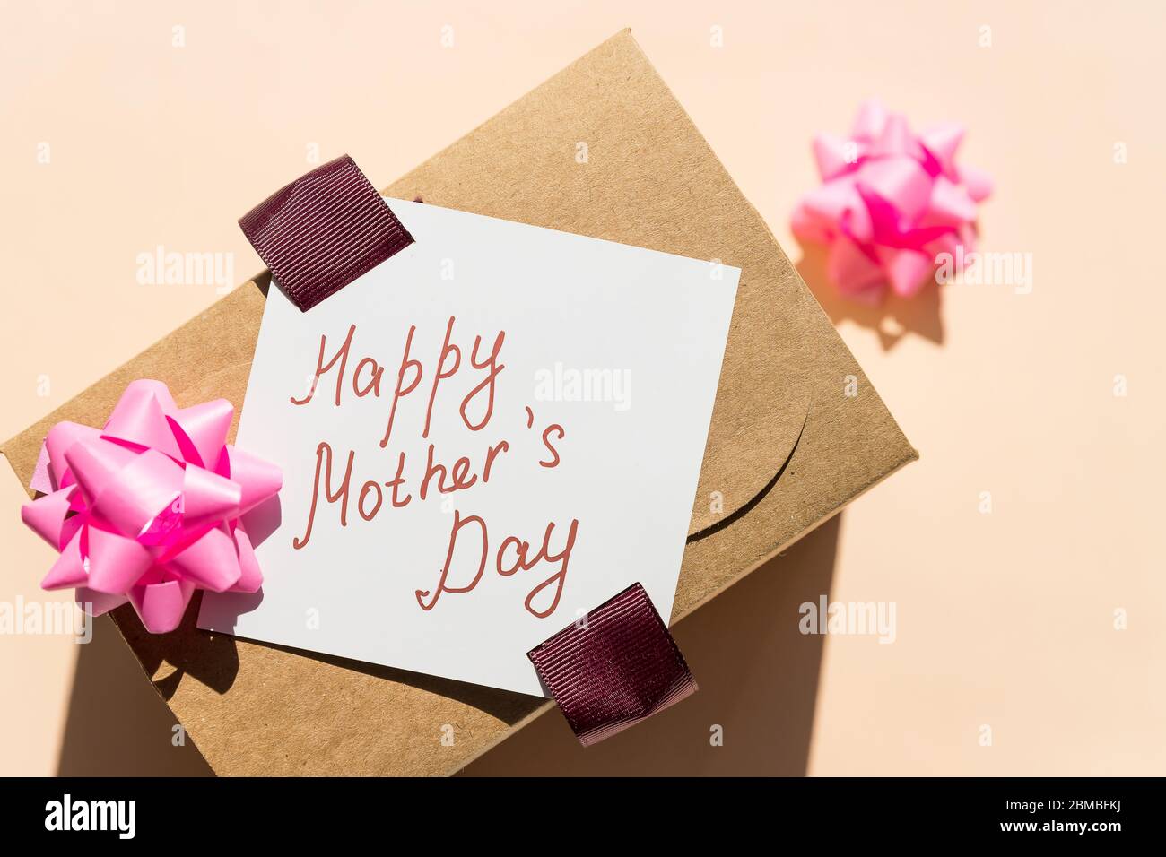 Message de la fête des mères avec cœur fait à la main. Carte de fête des mères.boîte cadeau de vacances sur fond pastel. Banque D'Images