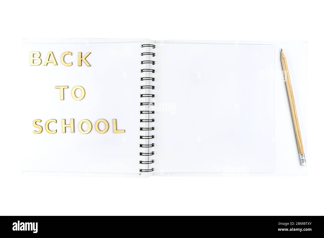 L'inscription « rentrée scolaire » est faite de lettres en bois qui se trouvent sur un carnet ouvert avec des pages blanches, isolées sur un fond blanc avec un masque Banque D'Images