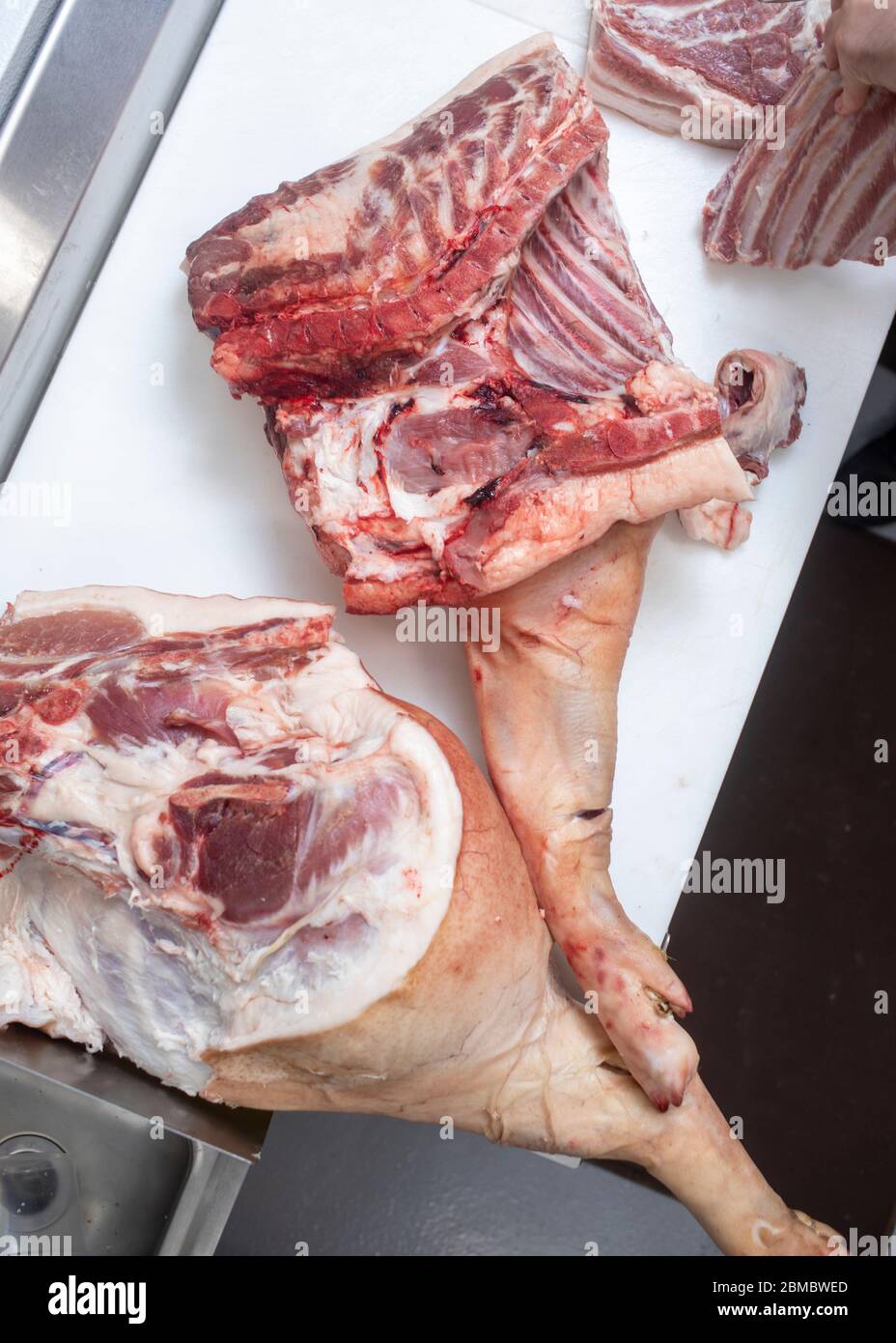 Des coupes entières de porc sont sur la table des bouchers sur un marché Banque D'Images