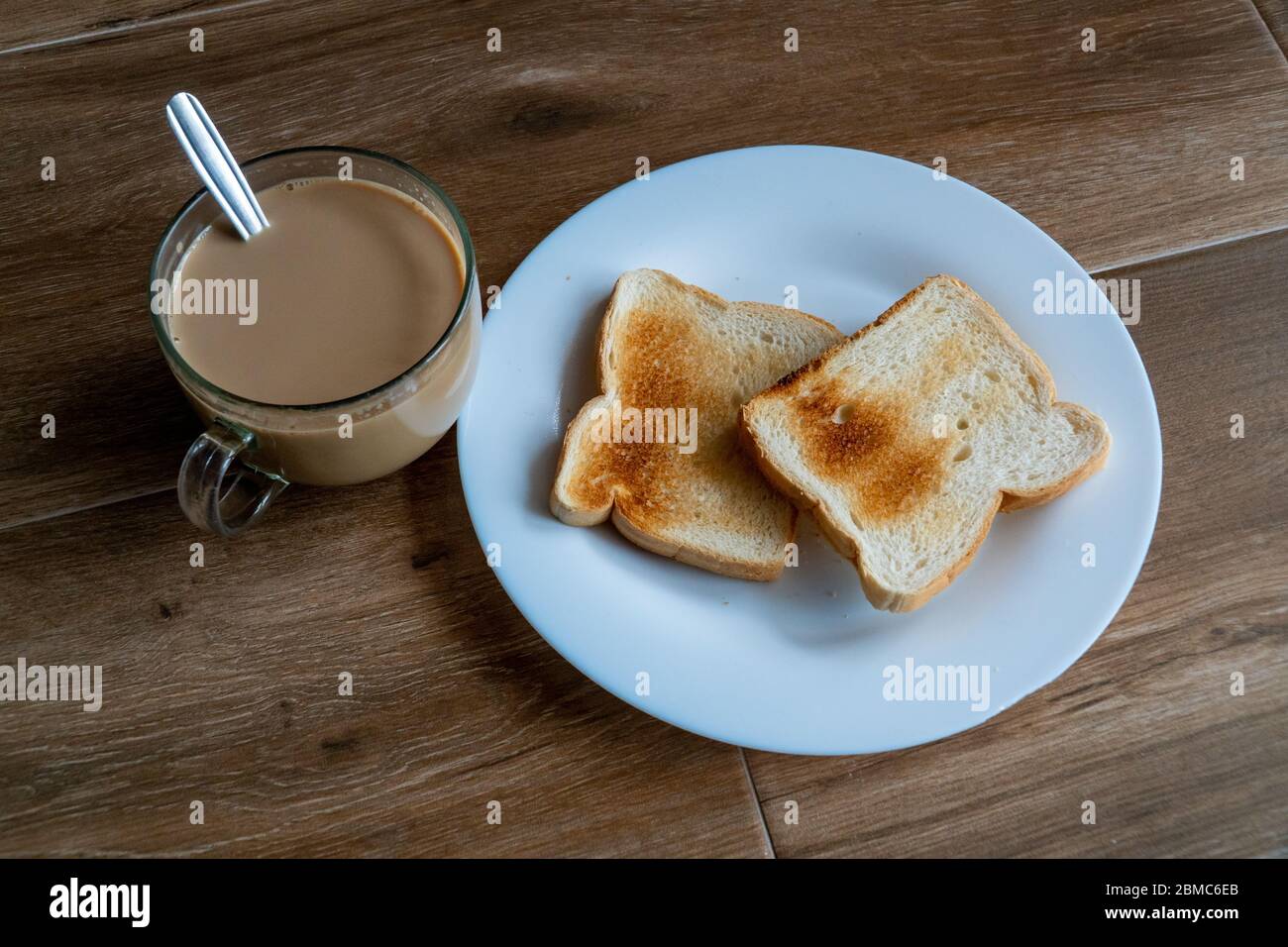 Tasse de café avec lait et deux tranches de pain croque-monsieur grillé sur une assiette blanche. Petit déjeuner sain avec café. Espace libre pour le texte. Vue latérale. Banque D'Images