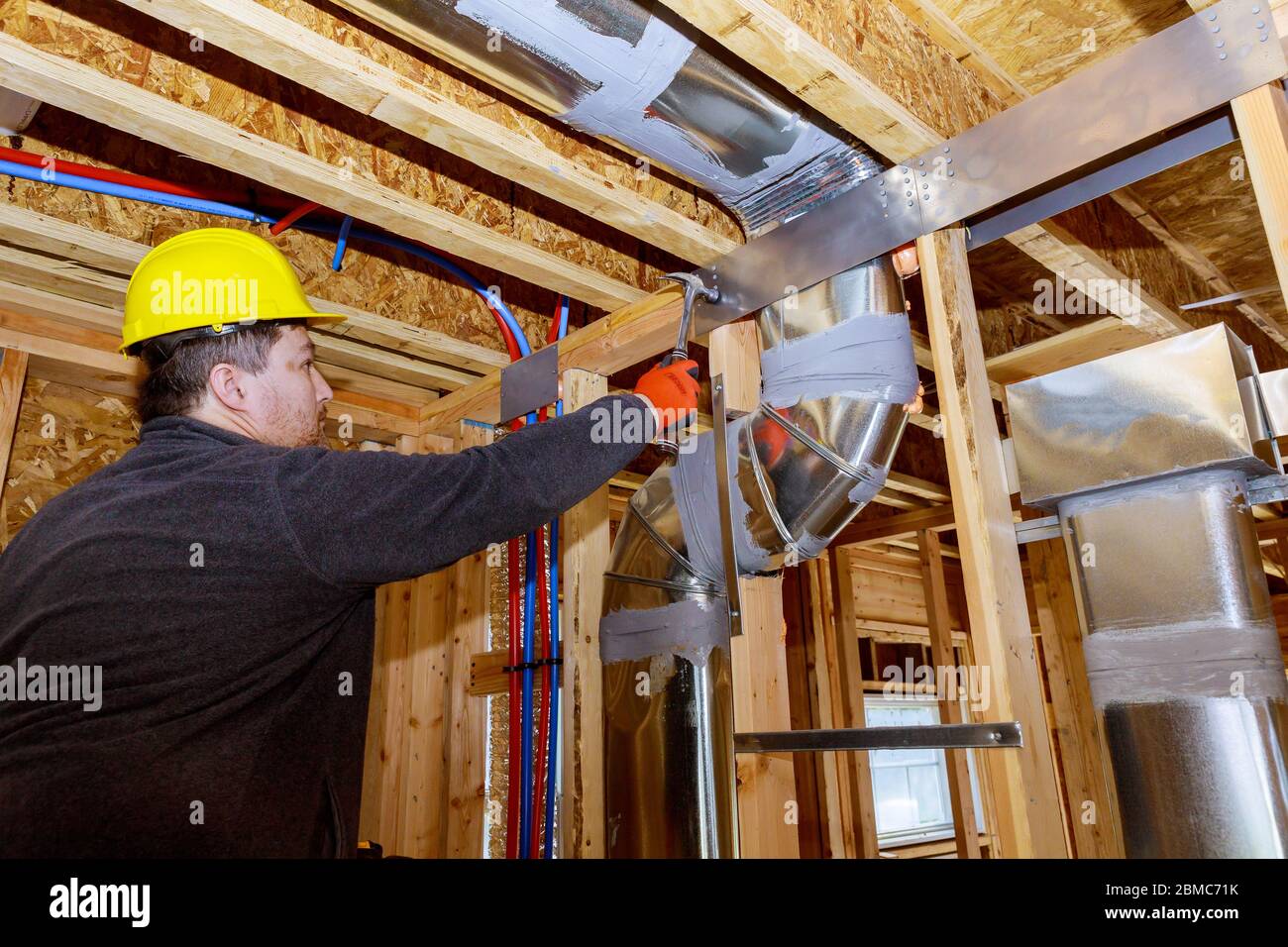 Les travailleurs qui font des conduits finaux de climatisation système HVAC les tuyaux de ventilation sont des supports de chauffage Banque D'Images