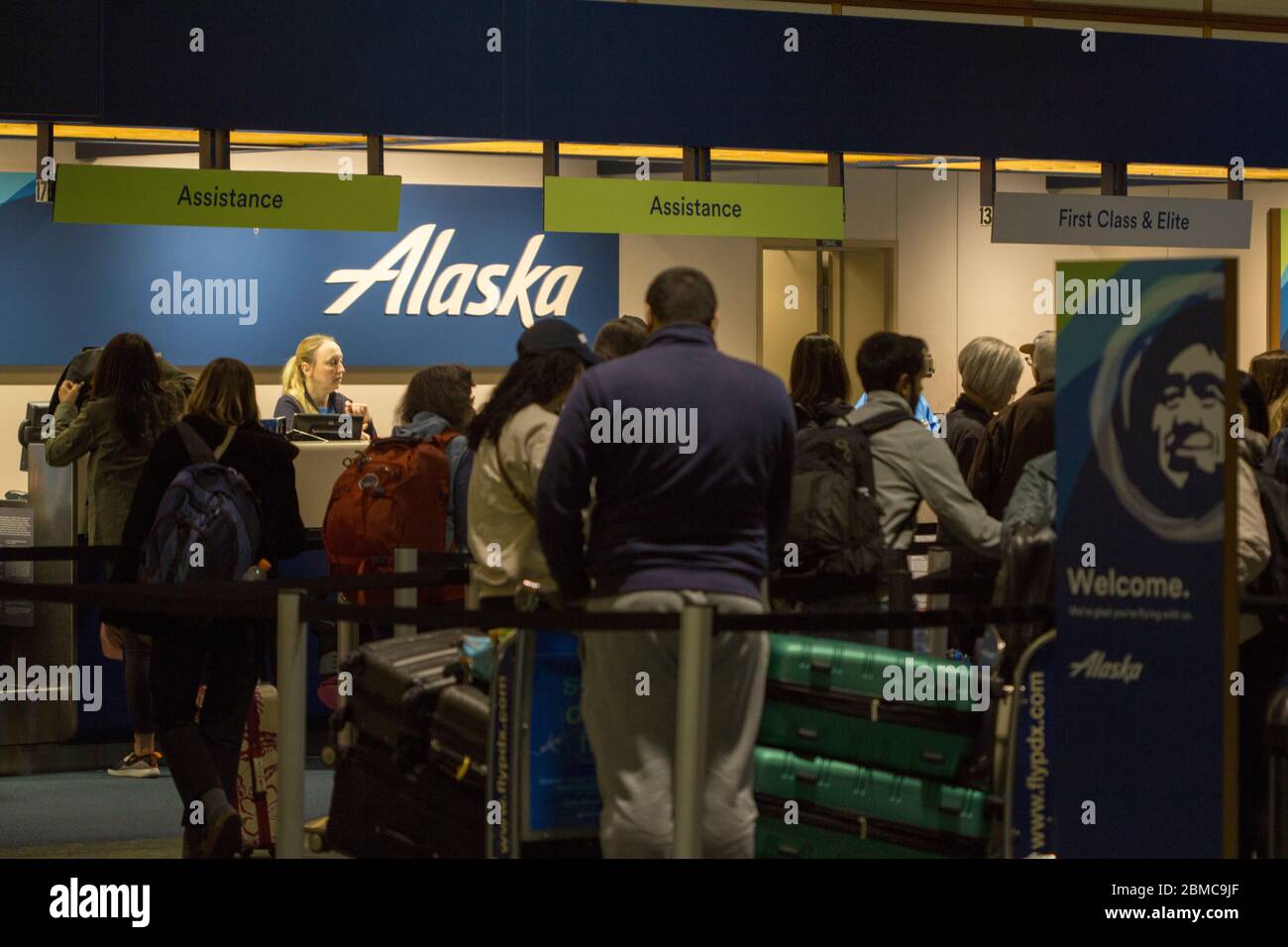 Les passagers qui font la queue pour vérifier leurs bagages au comptoir d'enregistrement d'Alaska Airlines à l'aéroport international de Portland la nuit le 13 février 2020. Banque D'Images
