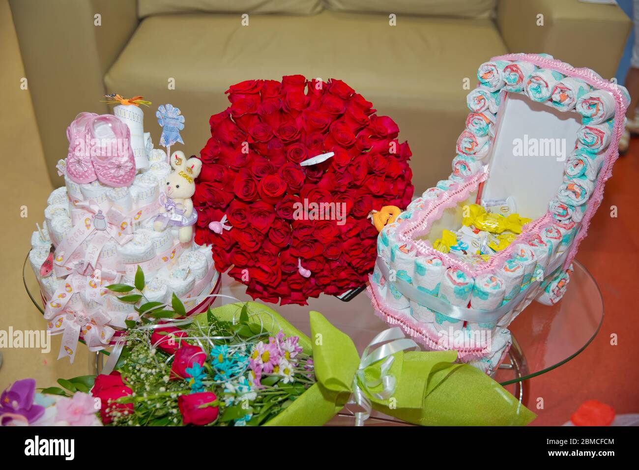 Un bouquet de fleurs bouquet de cent roses rouges . Grand bouquet de cent grandes roses rouges fleurs .Pink chaussures pour enfants . gâteau de nappy dans un Banque D'Images