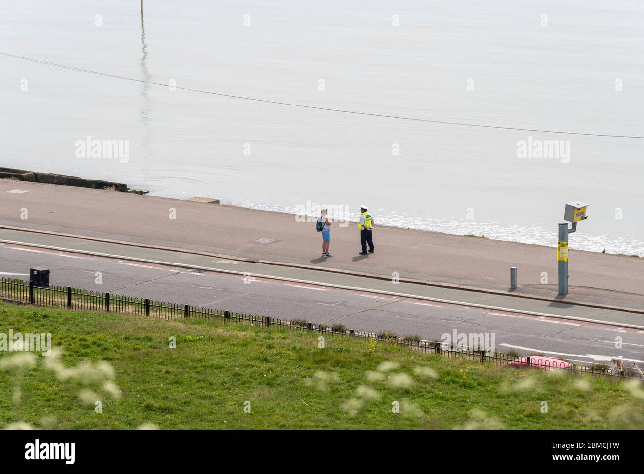 Un officier de l'application de la loi civile sur Southend on Sea, Essex, au Royaume-Uni, parlant à distance avec un membre du public à distance des lignes directrices de distance. Personne Banque D'Images