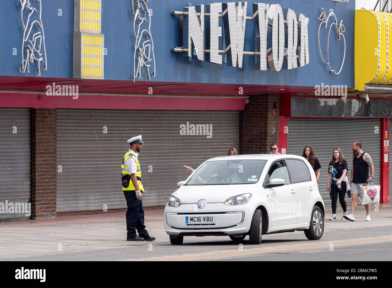 Un garde-trafic a indiqué à un chauffeur de voiture de se déplacer sur le front de mer de Southend lors de la Bank Holiday pendant la période de verrouillage du coronavirus COVID-19. Entreprise fermée Banque D'Images