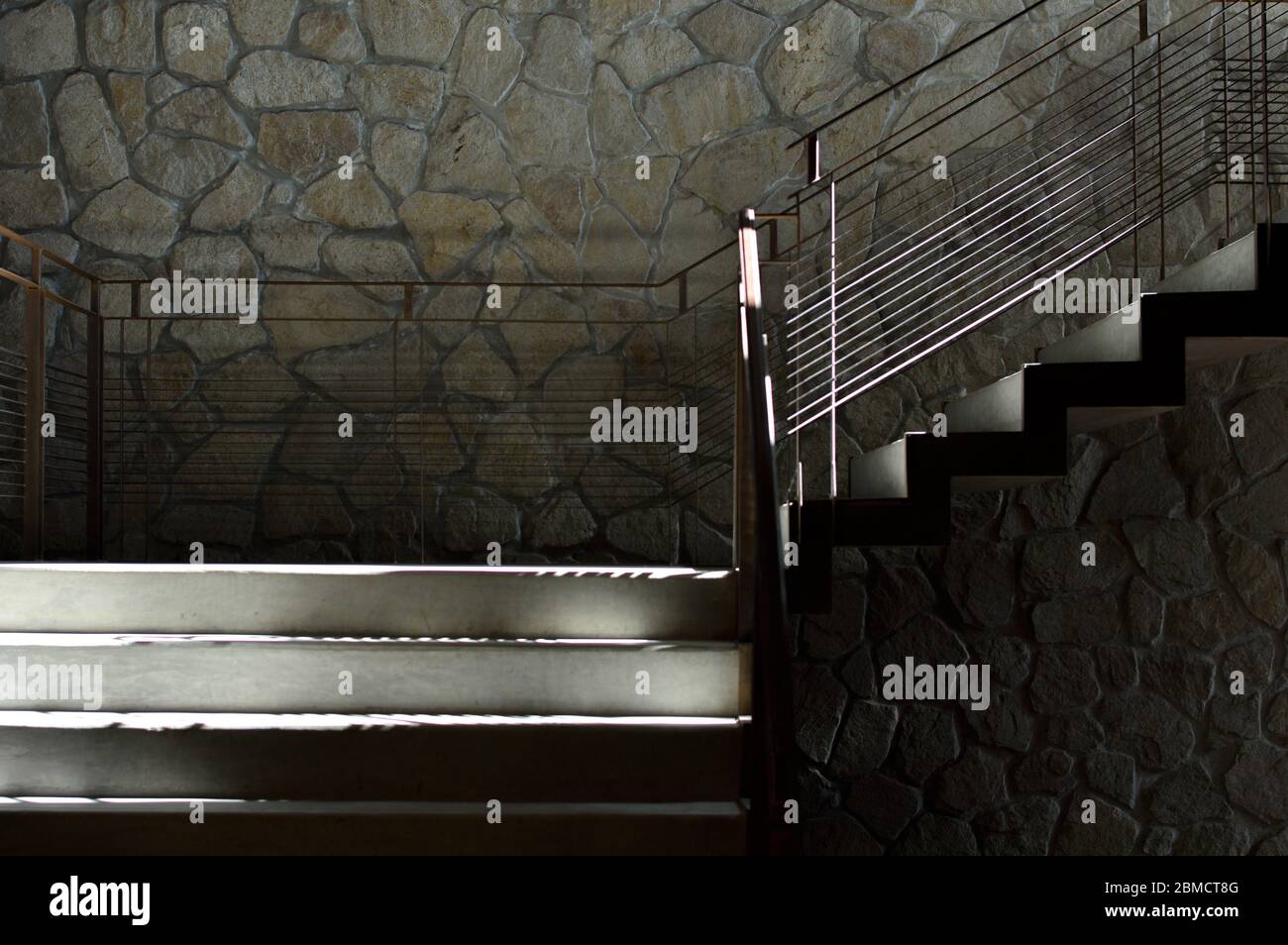 Escaliers industriels en béton et en métal au mur en pierre Banque D'Images