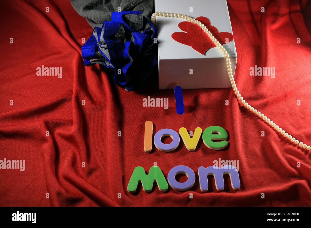 Lettres colorées avec ma maman d'amour isolée sur fond rouge de tissu. J'aime maman orthographié avec des lettres colorées et coeur rouge pour la fête des mères. Banque D'Images