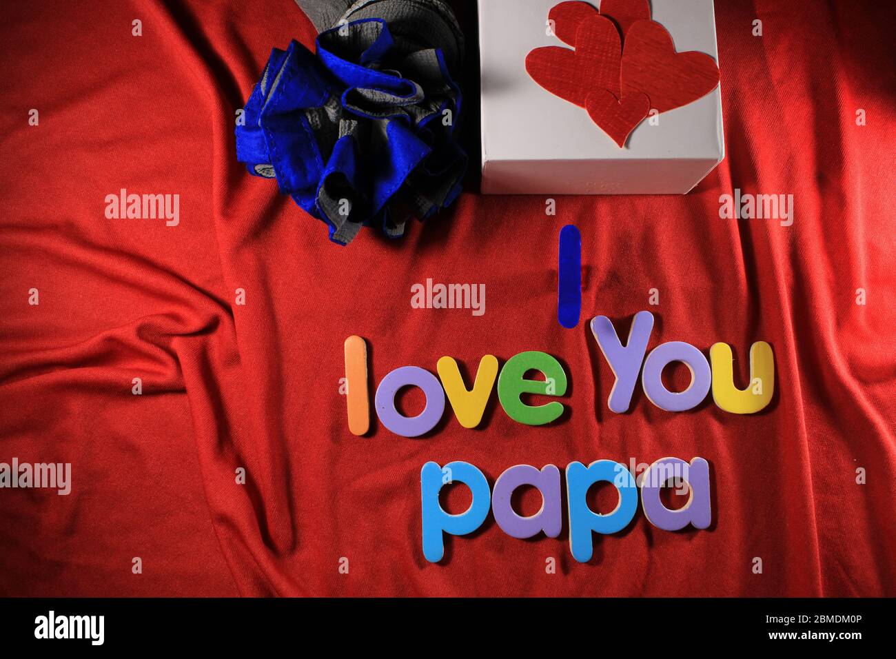 Lettres colorées avec je vous aime papa isolé sur fond rouge tissu. Je t'aime papa orthographié avec des lettres colorées pour le jour des pères. Banque D'Images