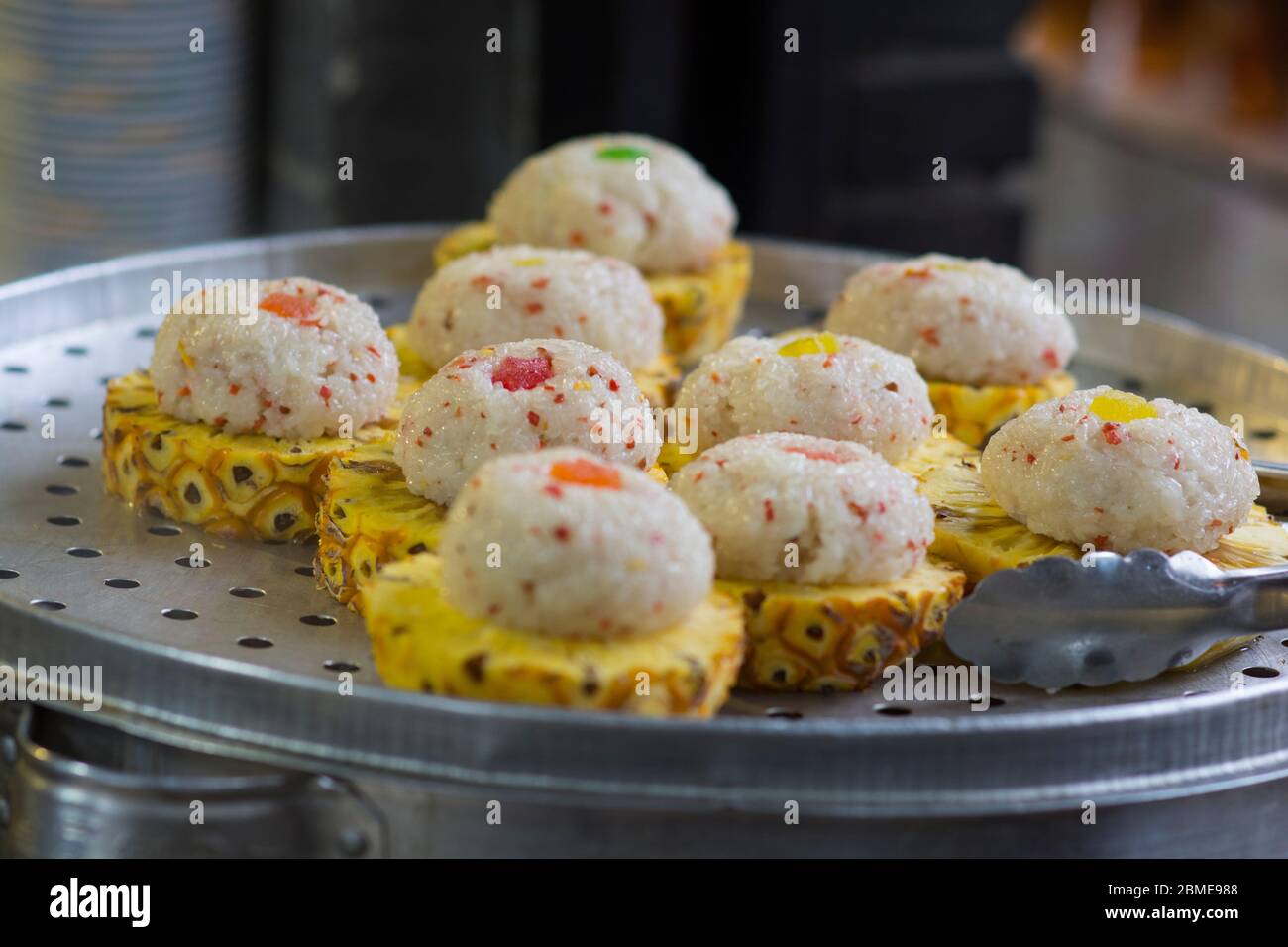 Dessert chinois, boules de riz vapeur sur des tranches d'ananas frais Banque D'Images