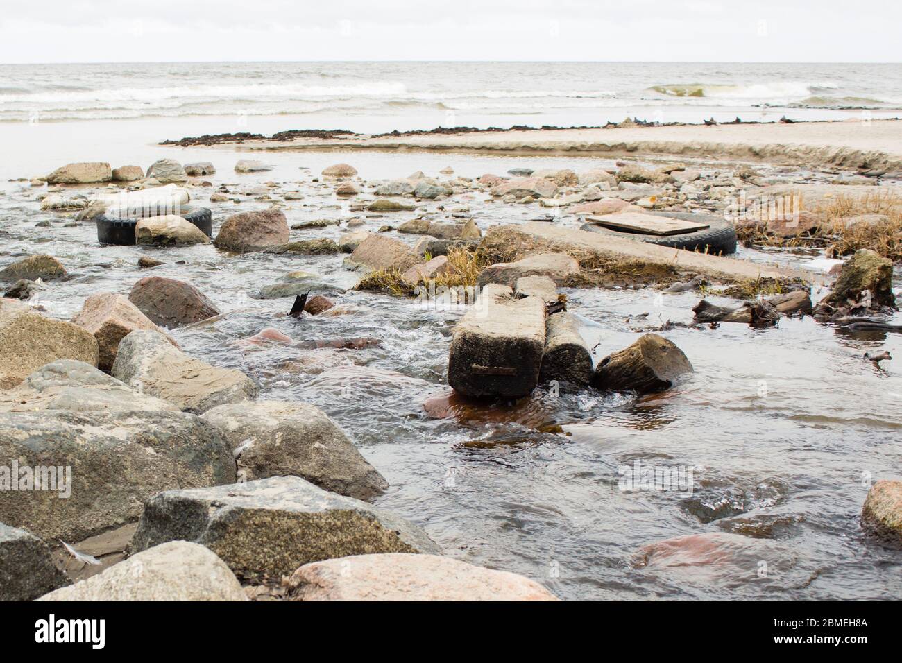 Une rivière polluée qui coule dans l'océan mondial. Banque D'Images