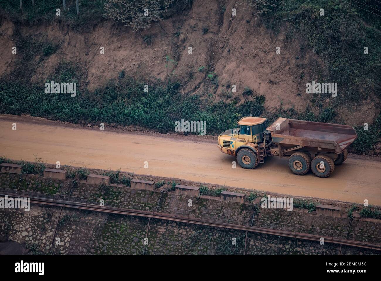 voiture en minerai de grande taille sur route boueuse Banque D'Images