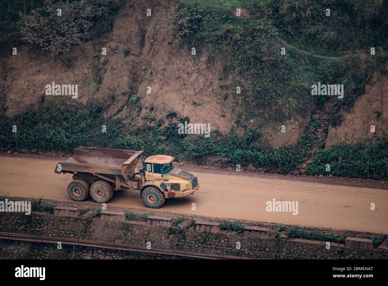 voiture en minerai de grande taille sur route boueuse Banque D'Images