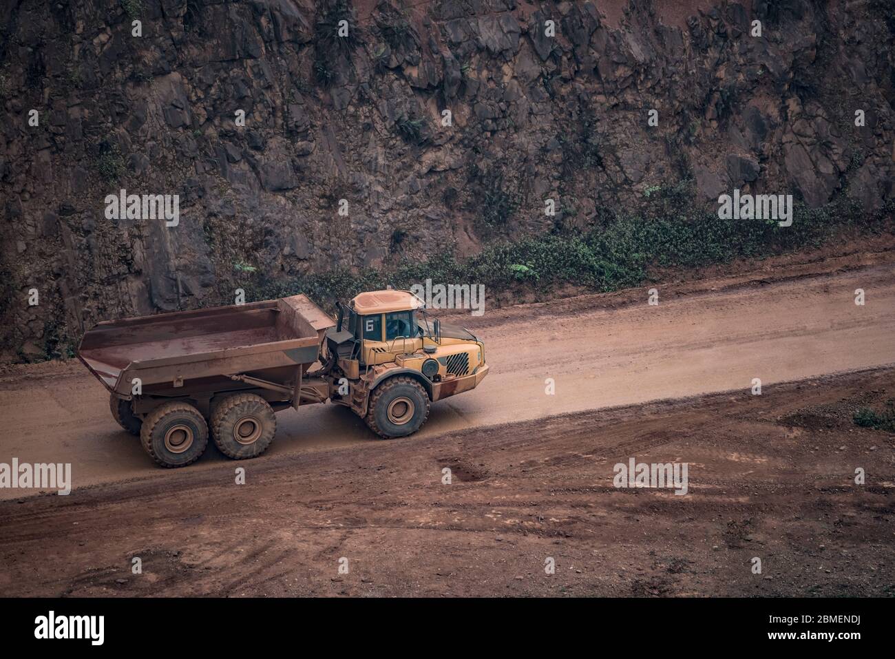 voiture en minerai de grande taille sur route boueuse Banque D'Images