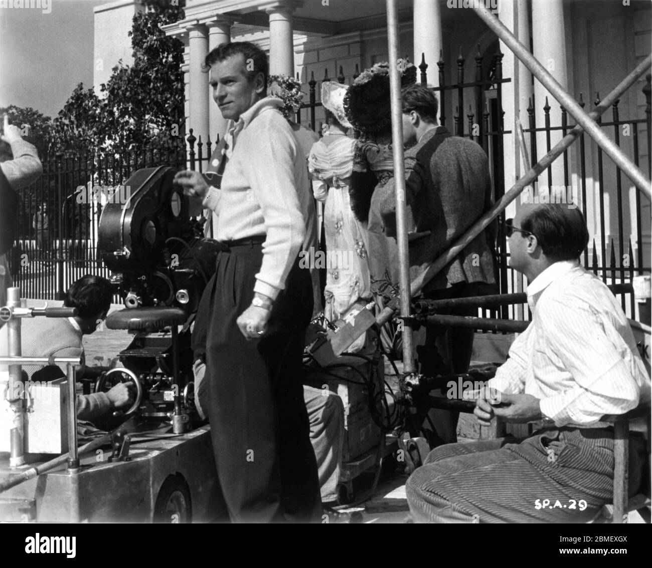 Le réalisateur LAURENCE OLIVIER et le cinéaste JACK CARDIFF (à droite en lunettes de soleil) avec l'équipe de caméra et des filles supplémentaires sur le plateau, en plein candif pendant le tournage du PRINCE ET DE LA DANSEUSE LAURENCE OLIVIER, jouer et scénario 1957, TERENCE RATTIGAN co-production UK-USA Marilyn Monroe Productions / Warner Bros. Banque D'Images
