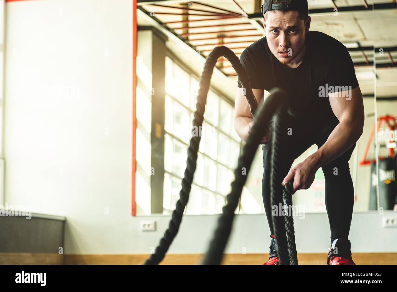 Faites de l'exercice dans la salle de gym avec des cordes. L'athlète est entraînement. Banque D'Images