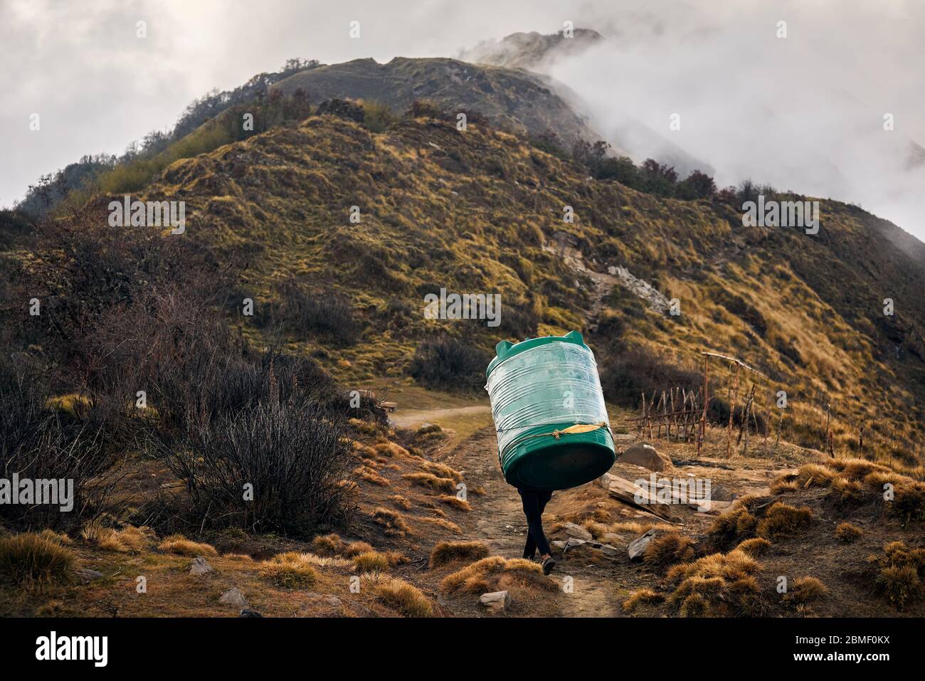 Le Népal Sherpa Porter exerçant son grand réservoir d'eau dans les montagnes de l'Himalaya, de l'Annapurna, Népal trekking Banque D'Images Le Népal Sherpa Porter exerçant son grand réservoir d'eau dans les montagnes de l'Himalaya, de l'Annapurna, Népal trekking Banque D'Images