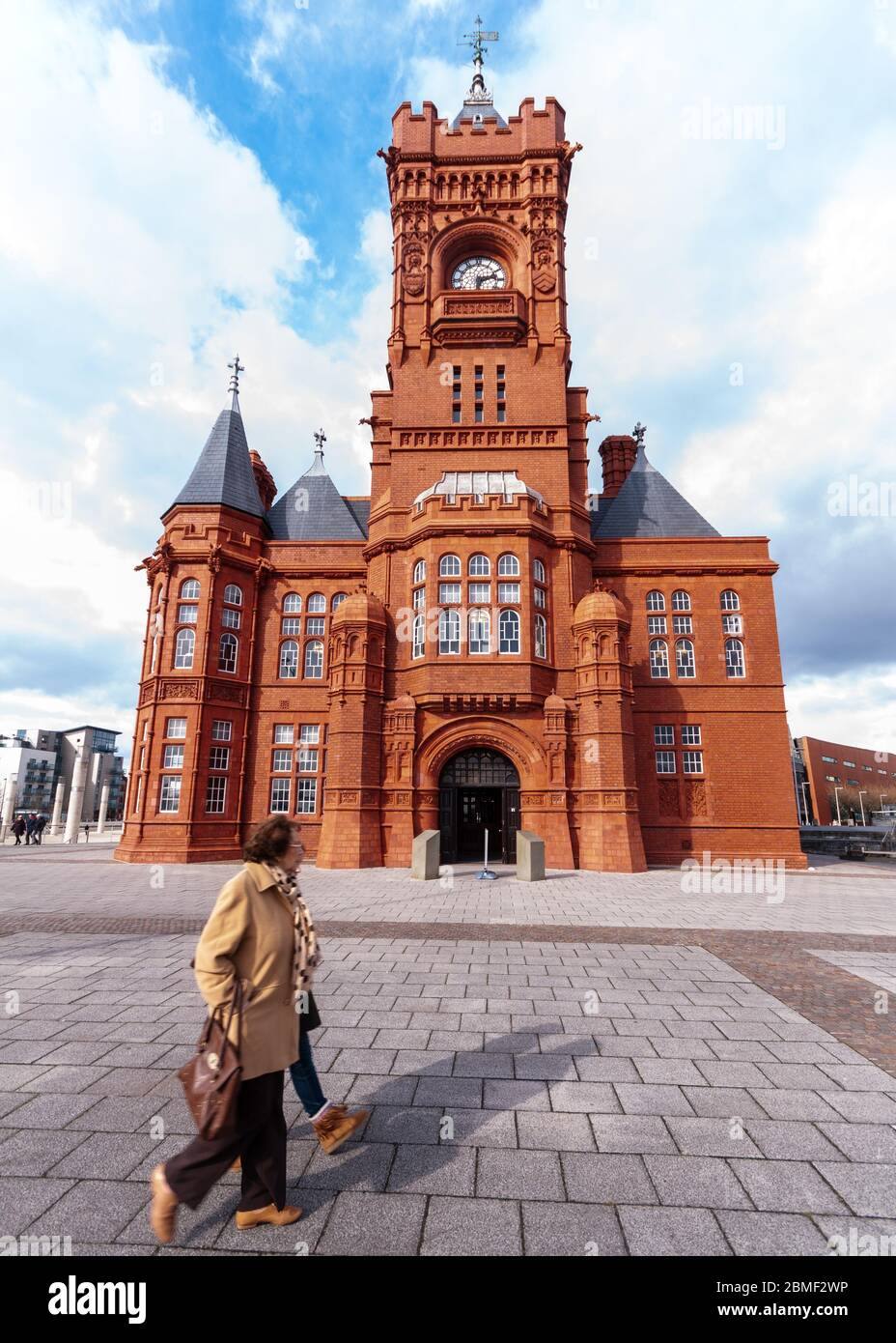 Cardiff, pays de Galles, Royaume-Uni - 17 mars 2013 : des piétons marchent le long du bâtiment victorien orné Pierhead dans la baie de Cardiff. Banque D'Images