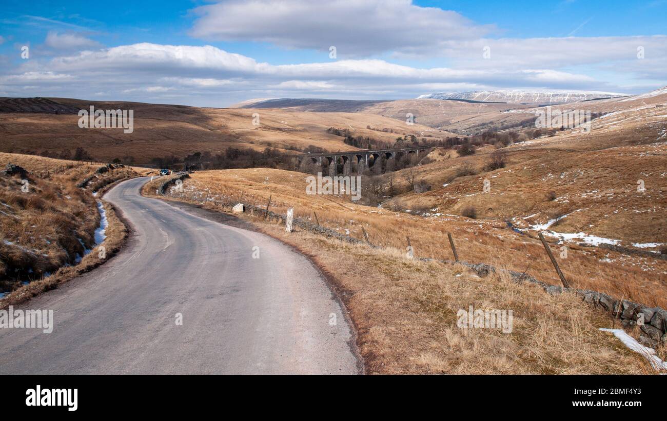 Une seule voie de campagne monte de Dentdale au-dessus du Viaduc Dent Head sur la ligne de chemin de fer Settle-Carlisle dans le paysage de landes vallonnés de Banque D'Images