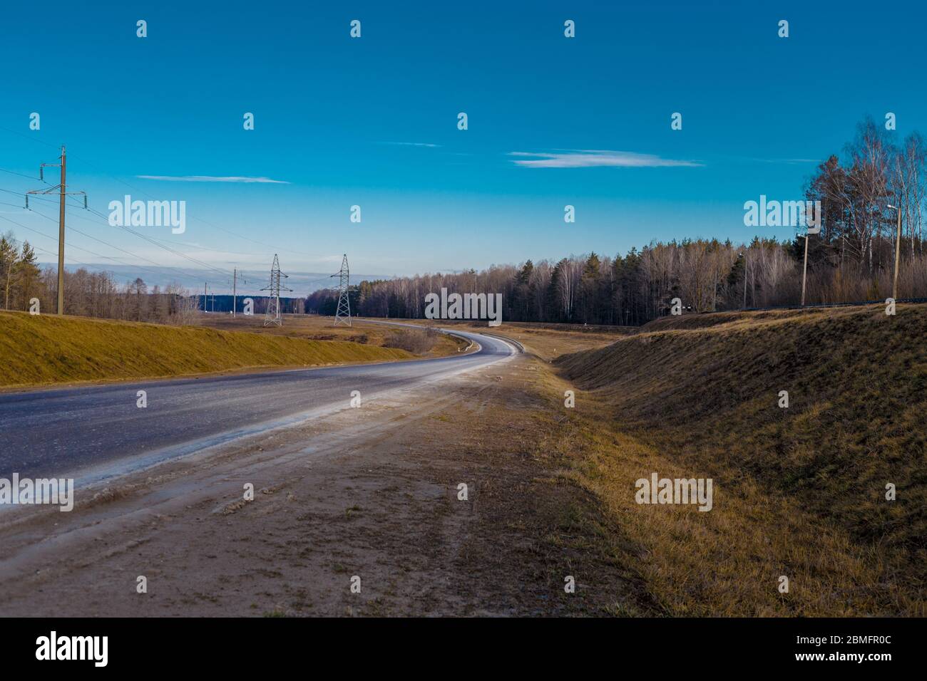 la route sur laquelle il n'y a pas de voitures passe par la forêt et le champ Banque D'Images