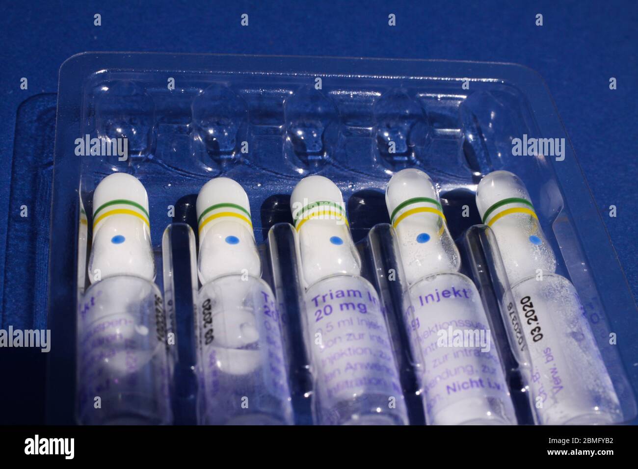 Viersen, Allemagne - mai 8. 2020 : gros plan d'une plaquette thermoformée isolée en plastique avec des flacons de 20 mg de cortisone Triam, fond bleu (point central) Banque D'Images