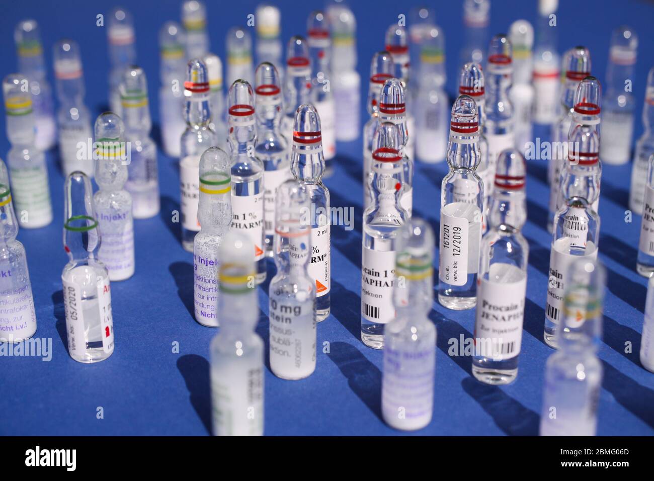 Viersen, Allemagne - mai 8. 2020 : gros plan des flacons en verre de médicament d'injection isolés, fond bleu (point central) Banque D'Images