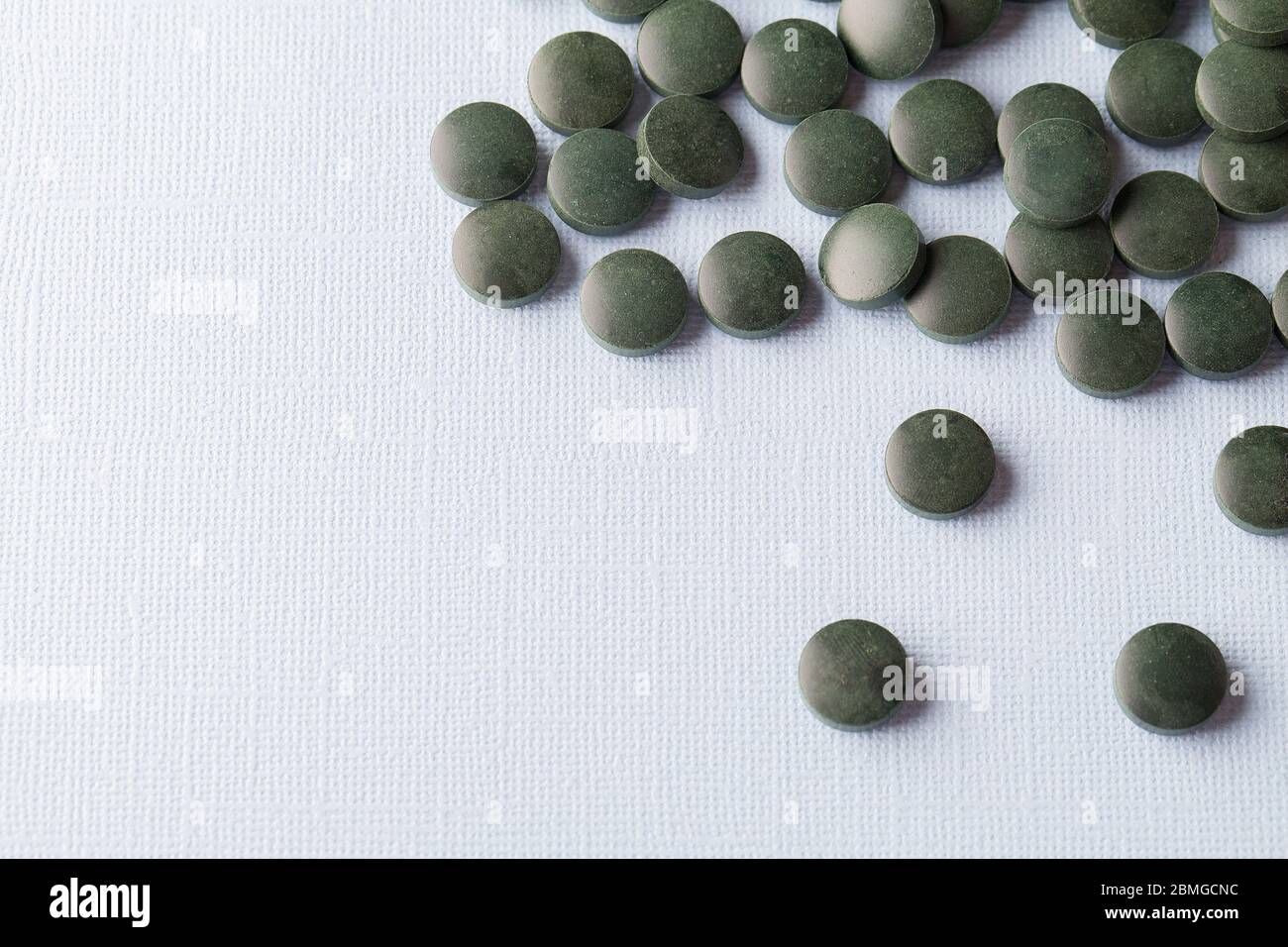 tablettes rondes vertes de spiruline sur fond blanc gros plan de l'espace de copie Banque D'Images