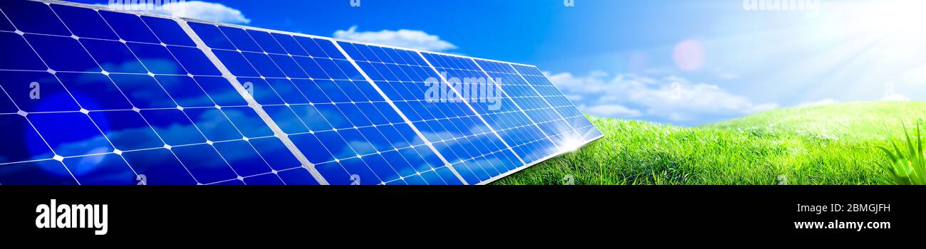 Panneaux solaires en vert herbe paysage avec ciel bleu et lumière du soleil - concept d'énergie propre Banque D'Images